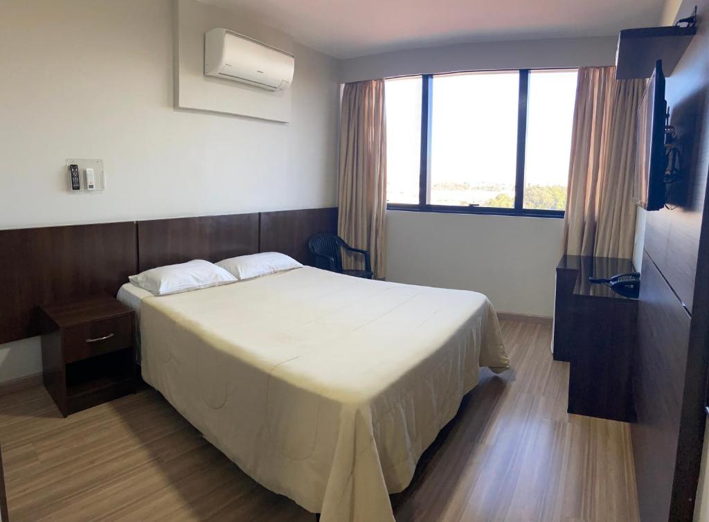 库里提巴伊塔马拉蒂酒店的一间卧室设有一张床和一个大窗户