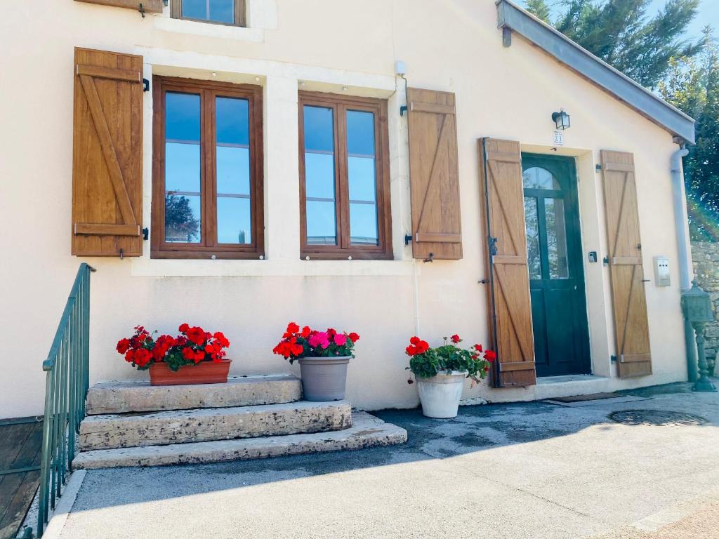 热夫雷尚贝尔坦Gevrey Wine Hôte的前门有两朵盆花的房子