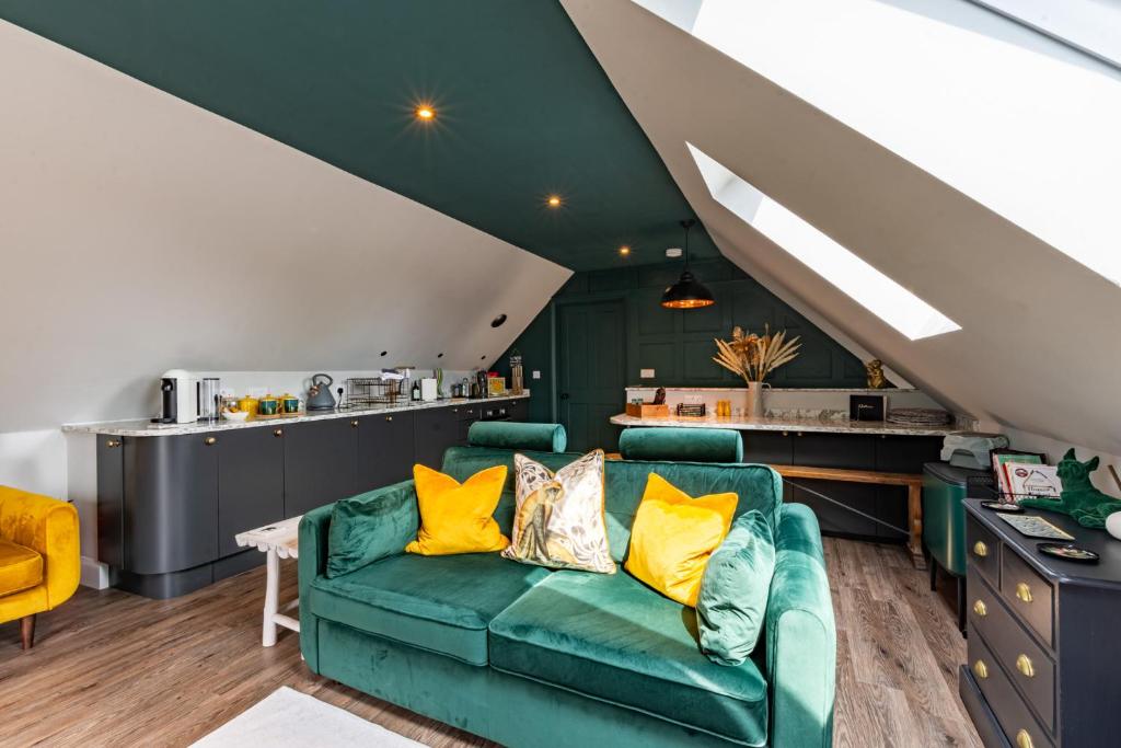 泰特伯里Stylish one bedroom Cotswold Coach House Tetbury的客厅配有绿色沙发和黄色枕头