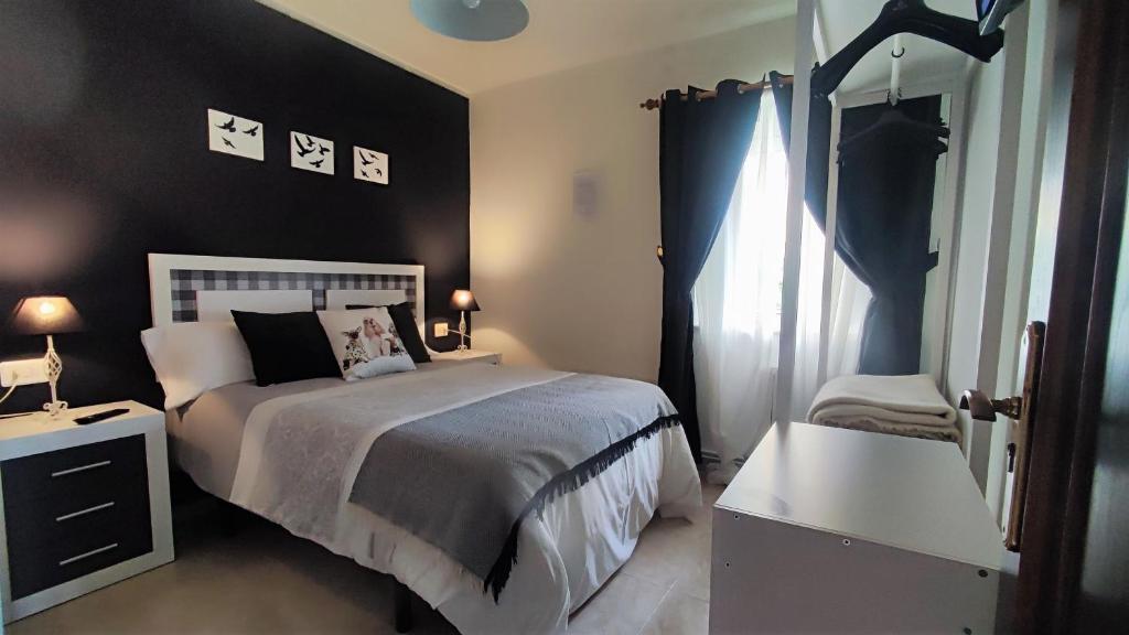 San Miguel de ReinanteMascotas Brais的一间卧室设有一张床和黑色的墙壁