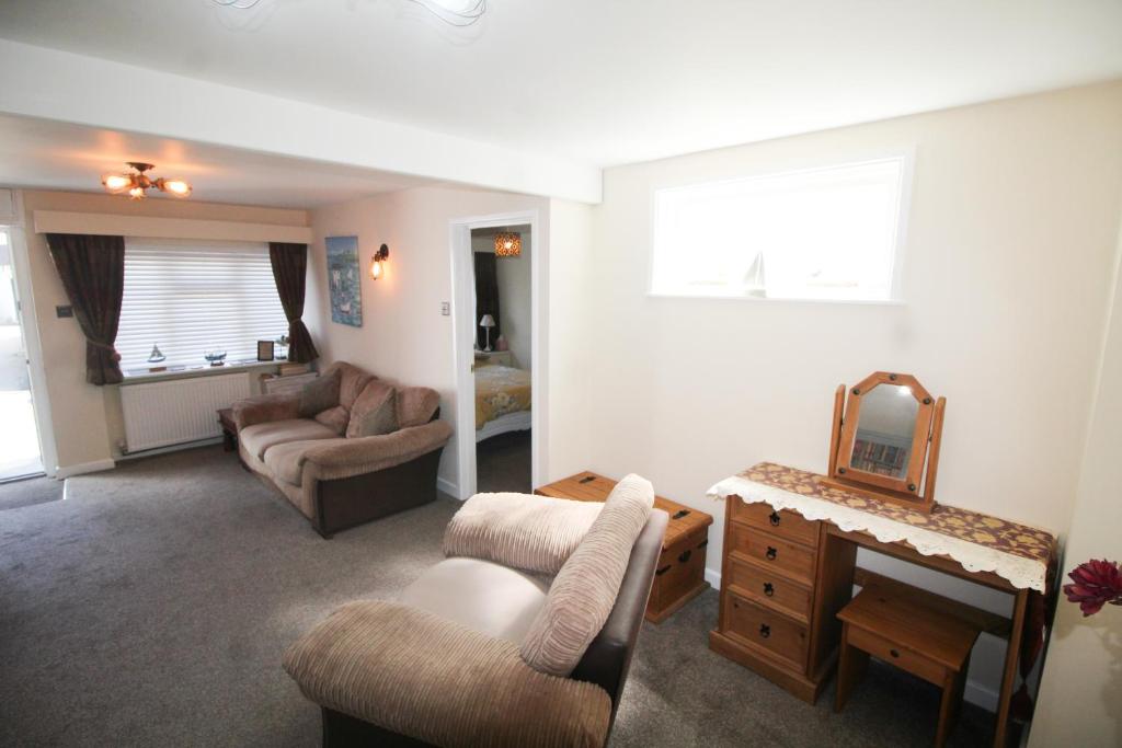 西卢港Briar Cottage的客厅配有沙发、椅子和镜子