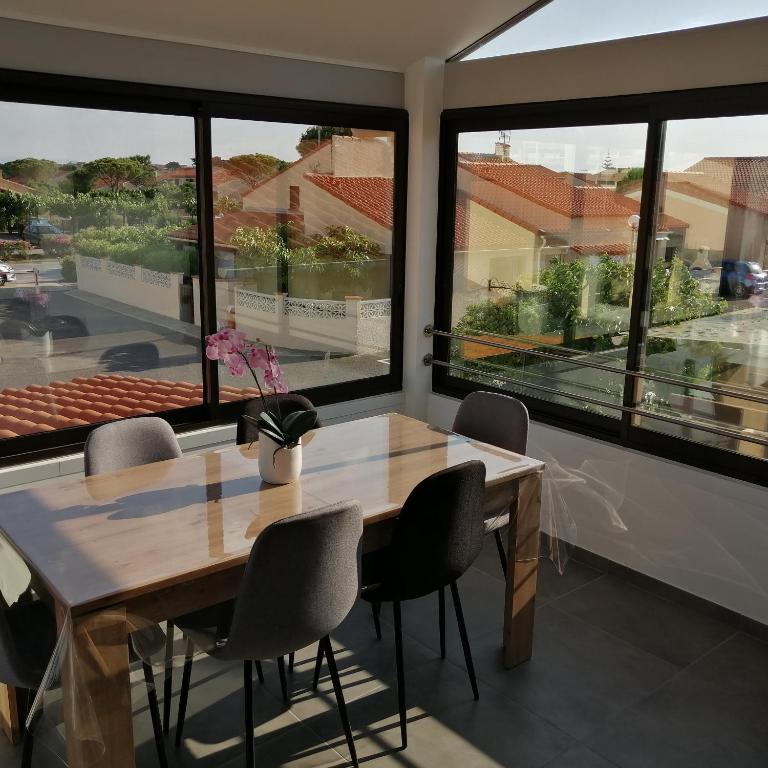 乐巴凯尔斯location maison de vacances jusqu&#39;à 6 personnes près du port et de la plage的一间有桌椅和窗户的餐厅