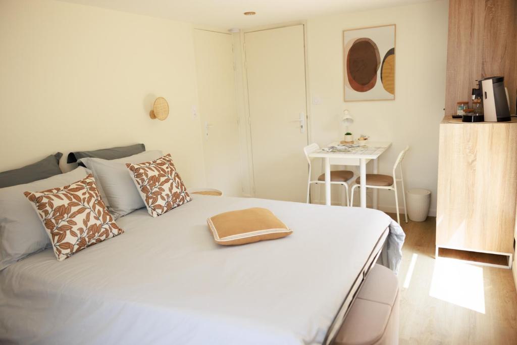 贝叶Pierre de Lune的卧室配有带枕头和桌子的白色床