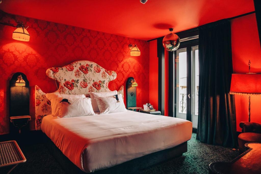 里斯本Pensão Amor Madam's Lodge的卧室设有红色的墙壁和一张大床