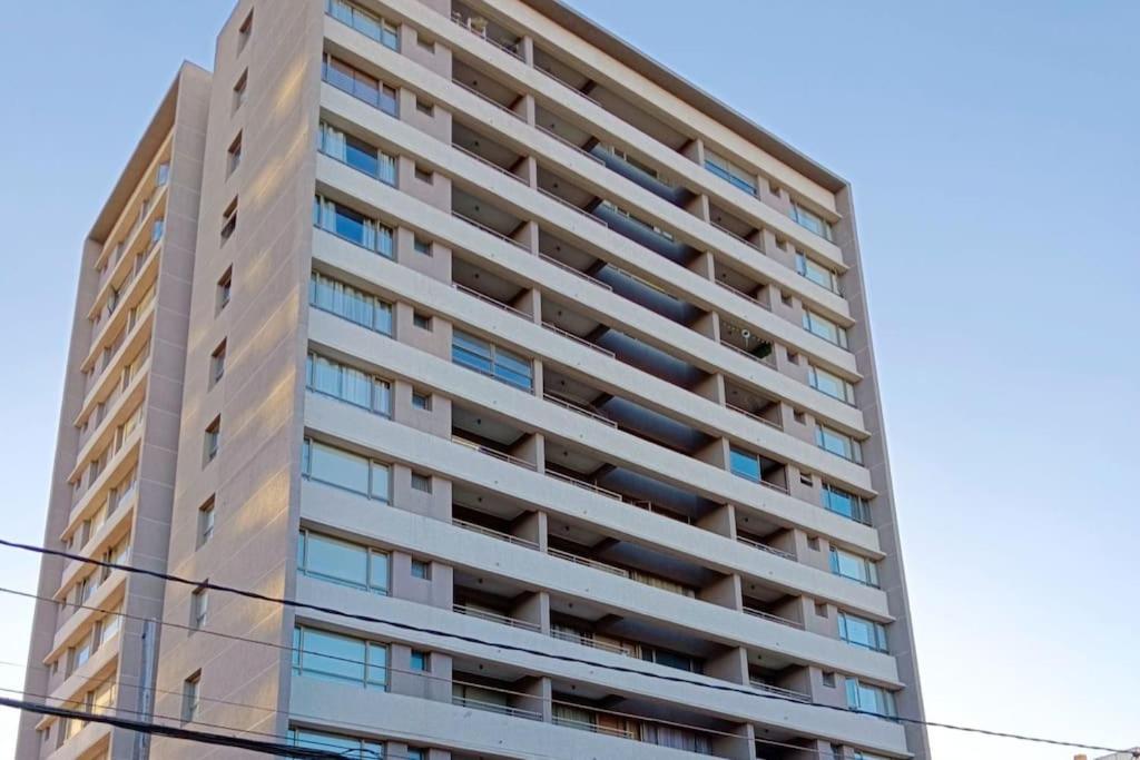 卡拉马Moderno Departamento en Calama的一座高高的公寓楼,设有窗户。