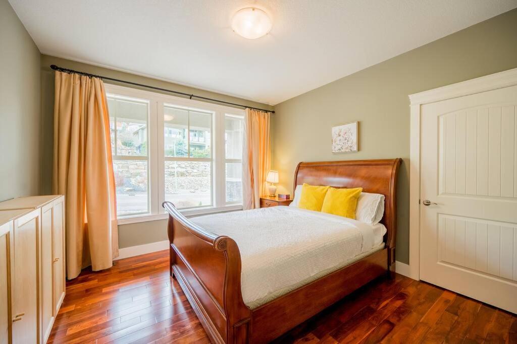 基洛纳Kelowna Spacious 2 Bedrooms House的一间卧室配有一张带黄色枕头的床和一扇窗户