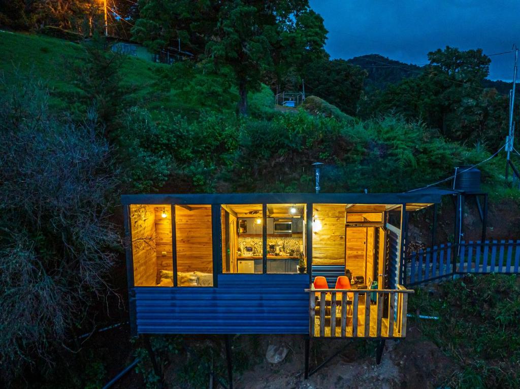RivasTiny House Jaulares的夜晚山上的蓝色小房子