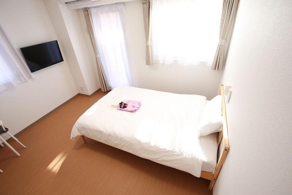 大阪Connect Inn的卧室配有白色的床和毛巾