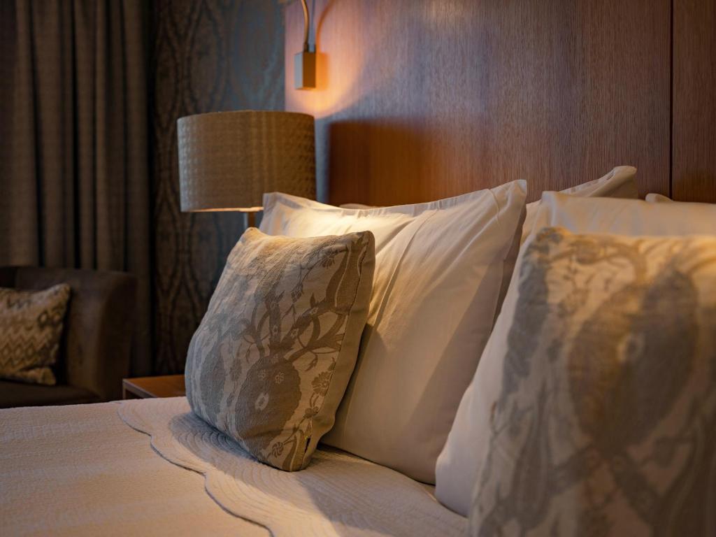 北哈夫洛克普特斯精品酒店的酒店的客房 - 带枕头和灯的床