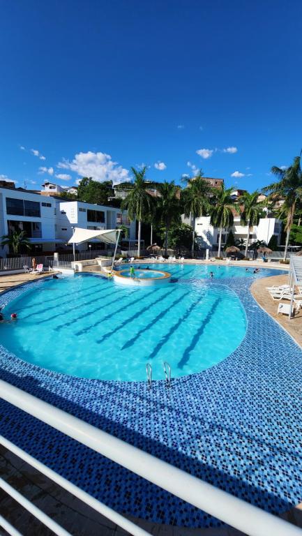 圣菲德安蒂奥基亚Apartasol Ciudadela Santafe - Santa Fe de Antioquia的一座拥有蓝色海水和棕榈树的大型游泳池
