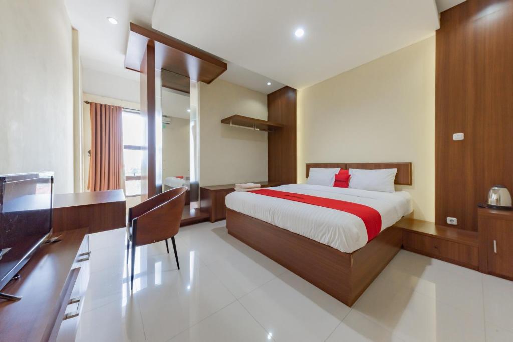 苏加武眉RedDoorz Syariah near Alun-Alun Pelabuhan Ratu的一间卧室配有一张床、一张书桌和一台电视