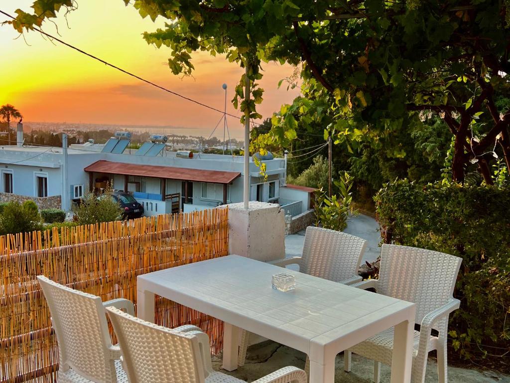 科斯镇Greek House Tatiana的白色的桌椅,背面是日落