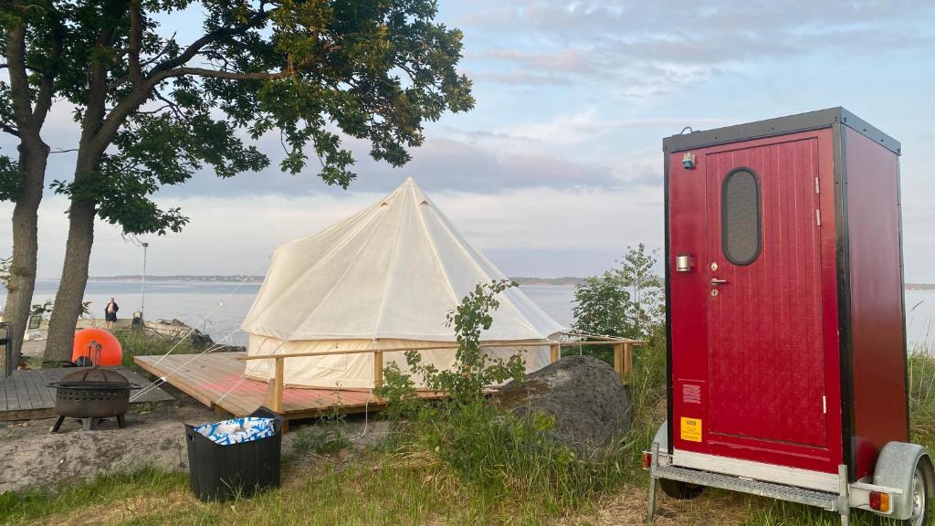 DrottningskärAspö Glamping的湖畔的帐篷和拖车