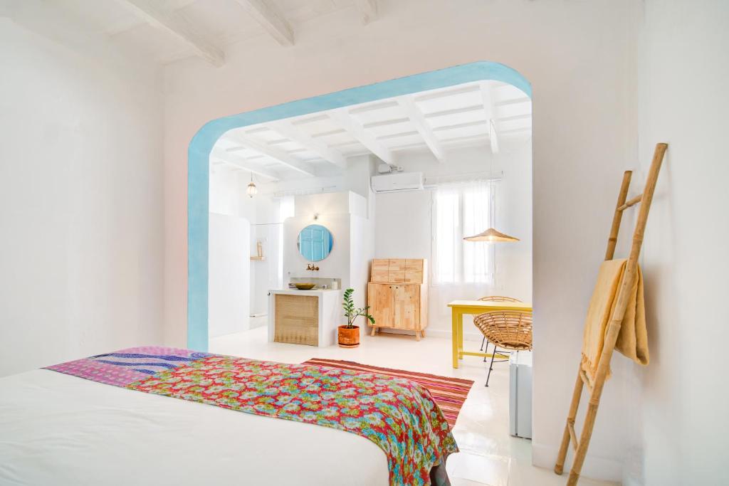 休达德亚La Cayena Rooms的白色的客房配有一张床和一张桌子