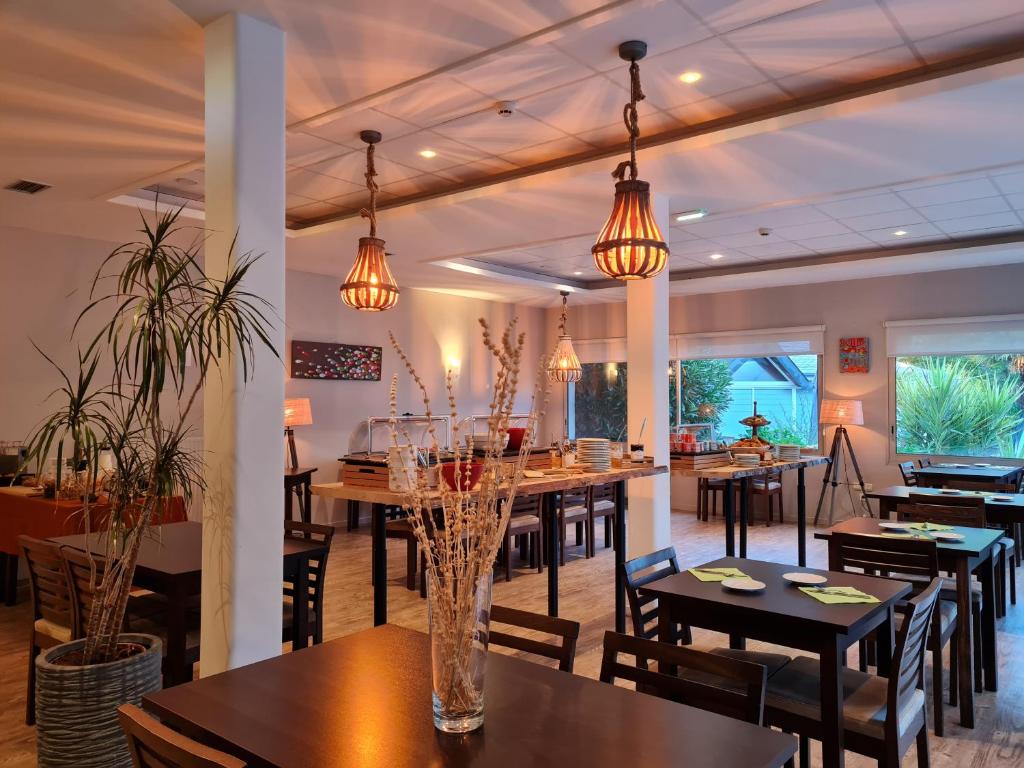 普罗梅尔Hôtel du Golf Saint-Laurent的一间带桌椅和灯光的餐厅