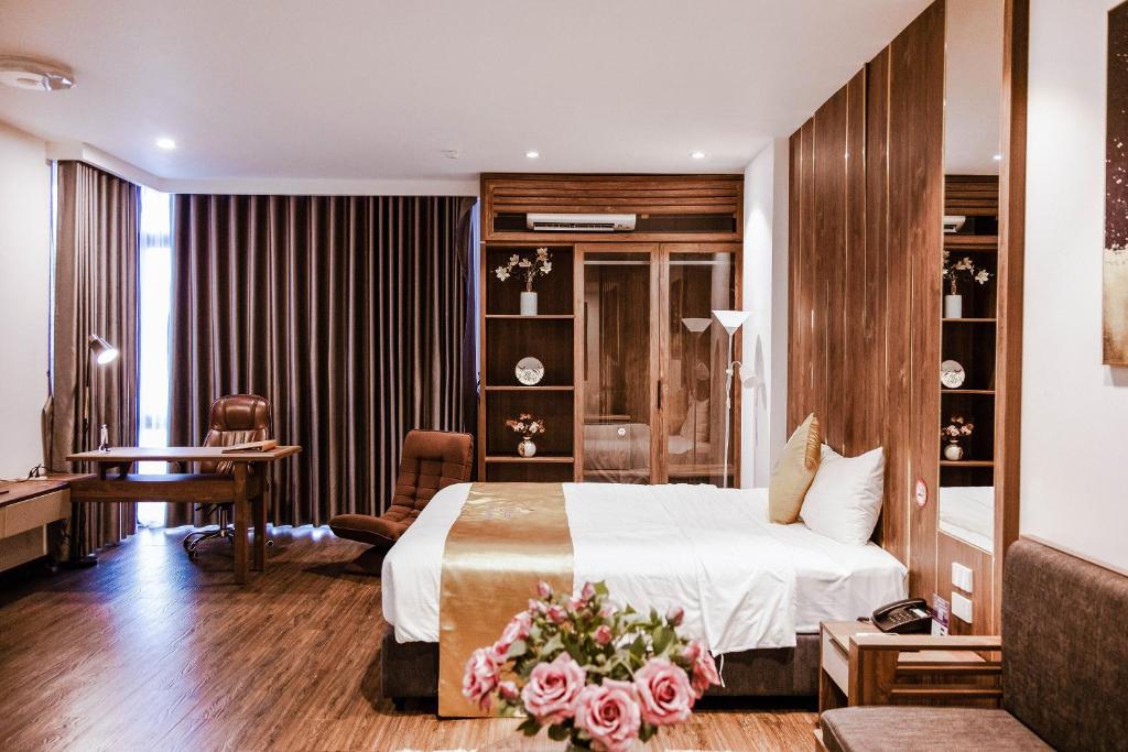 海防IRIS Hotel Hải Phòng的配有一张床和一张书桌的酒店客房
