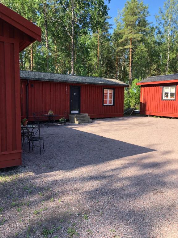 ForshagaLillemyrsgården的一座红色的建筑,前面设有野餐桌