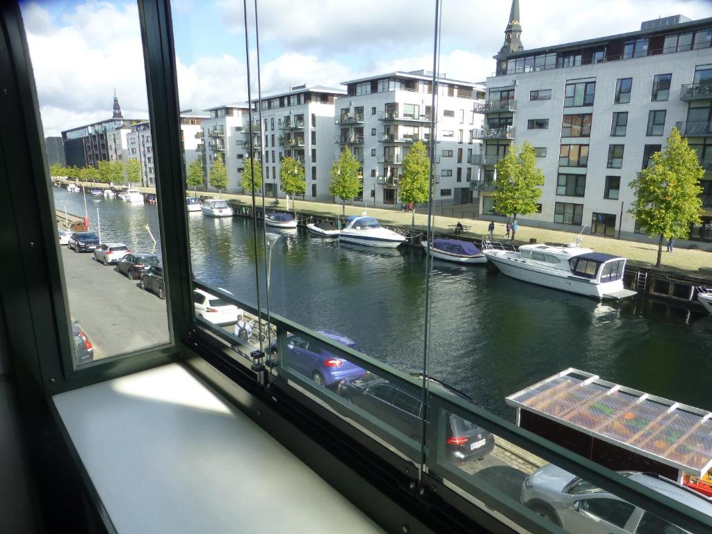 哥本哈根Christianshavn Apartments 536的从带船的河流窗户欣赏美景