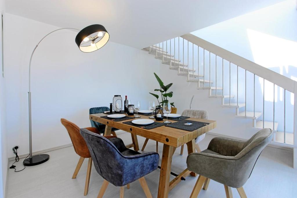 伍珀塔尔Luxus über 2 Etagen mit Balkon in Elberfeld的一间带木桌和蓝色椅子的用餐室