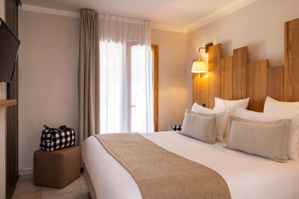 卡普费雷Domaine du Ferret Restaurant & Spa的一间设有大床和窗户的酒店客房