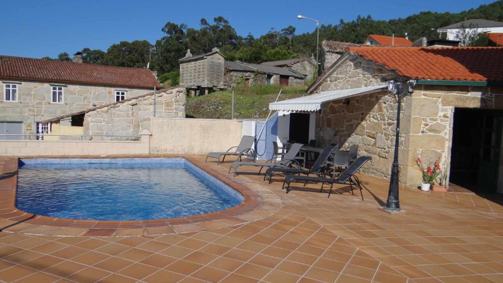 穆罗斯Casa da Mirina Casita para 2的一个带游泳池和椅子的庭院和一座建筑