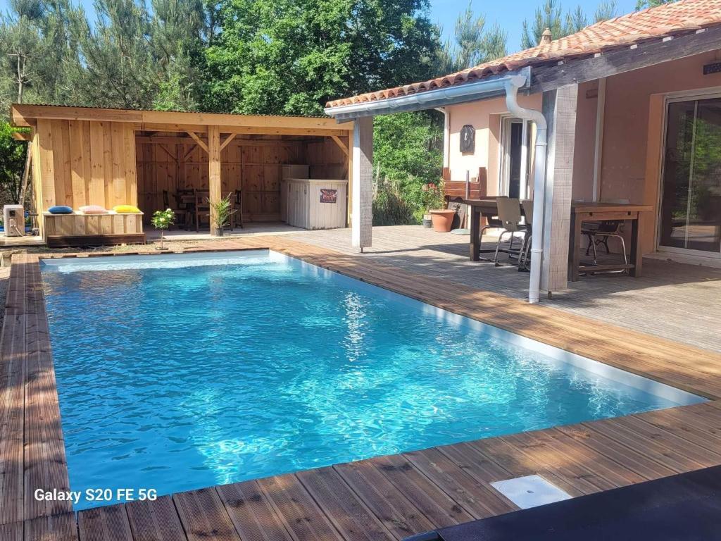 BélietGrande maison de vacances 12pers PISCINE的一个带甲板和房子的游泳池