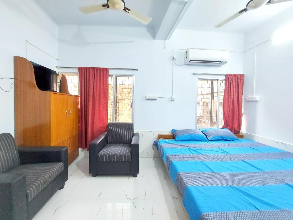 博尔普尔Chaiti Lodge - Santiniketan Bolpur的一间卧室配有两张床和椅子