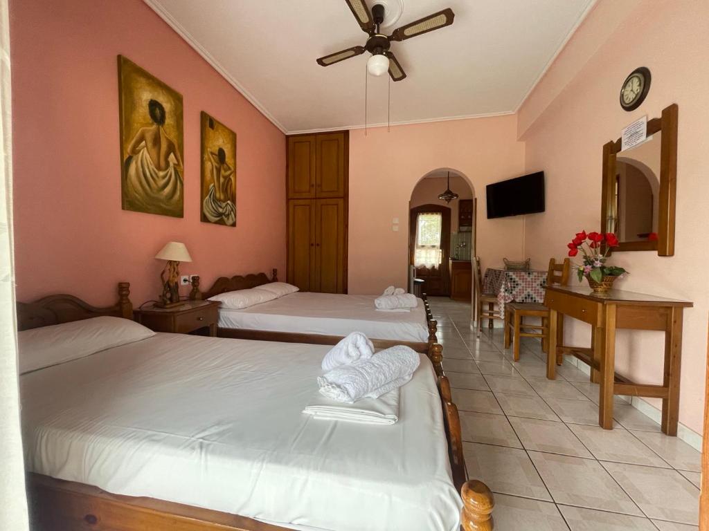 卡拉内拉Diamantoula Rooms的酒店客房设有两张床和一张桌子。