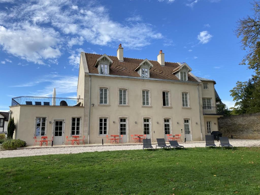 萨维尼莱博恩Manoir de Villamont的前面有椅子的大白色房子
