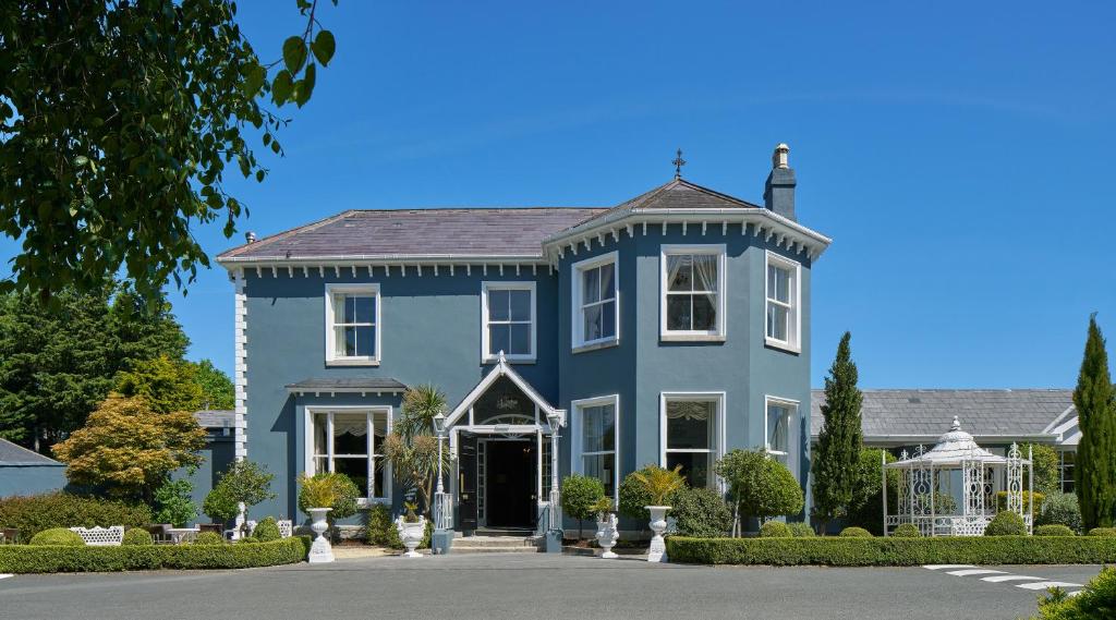 恩尼斯凯里夏山酒店的一座带前院的大型蓝色房屋