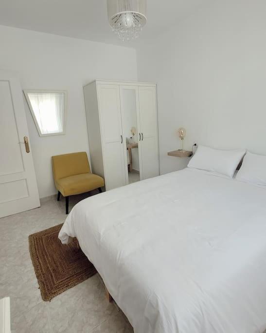 萨莫拉Casa Tonino: Encantadora casa junto al Río Duero的卧室配有一张白色大床和一把椅子