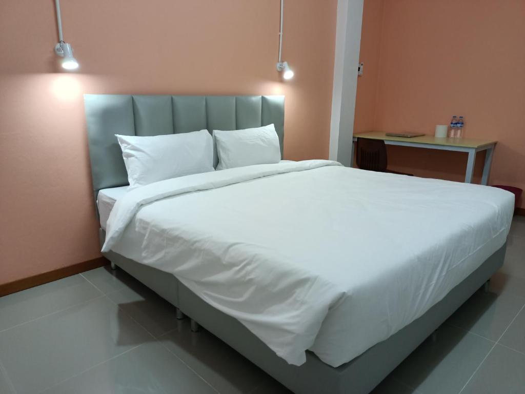 佛丕โรงแรม เดอะพีช / The Peach hotel的卧室配有一张带白色床单和枕头的大床。