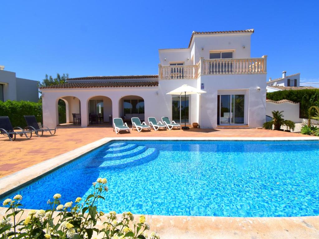 哈维亚Casa la Finca的别墅前设有游泳池