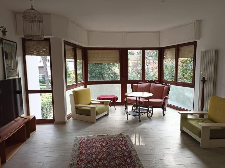 蒂勒尼亚Tirrenia Appartamento Girasoli的客厅配有椅子和桌子,设有窗户
