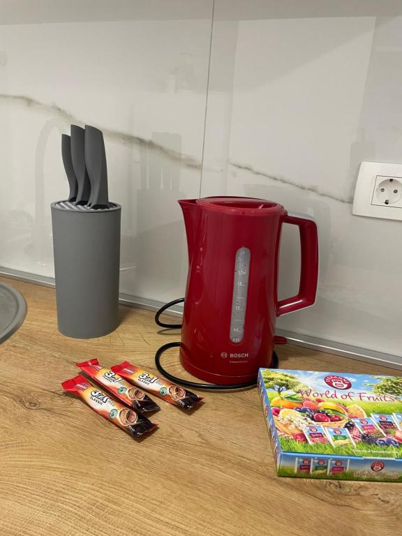 克宁Apartman Stela的红色投掷器和餐具及一盒糖果