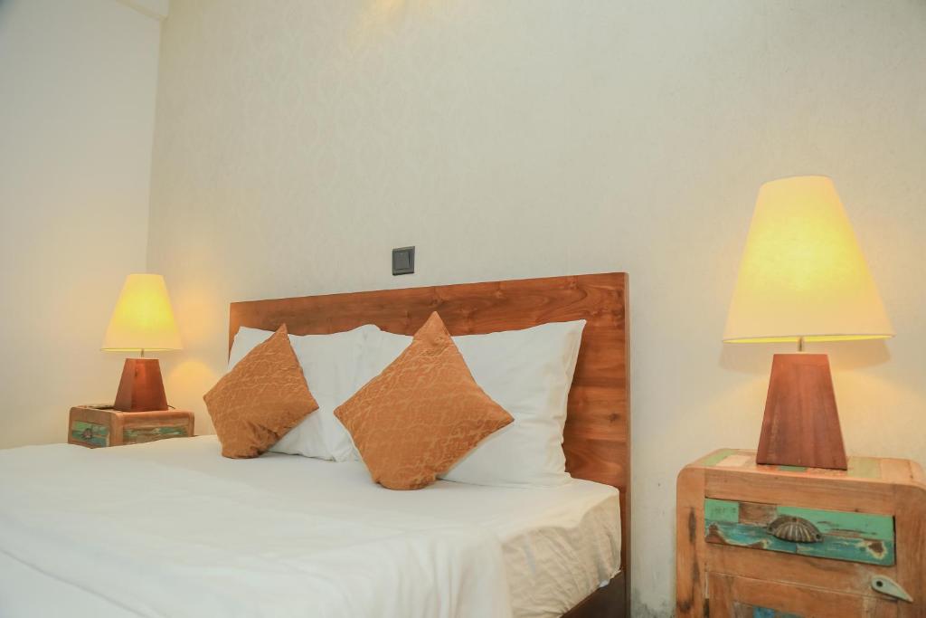 努沃勒埃利耶Grace的一间卧室配有一张带枕头的床和两盏灯。