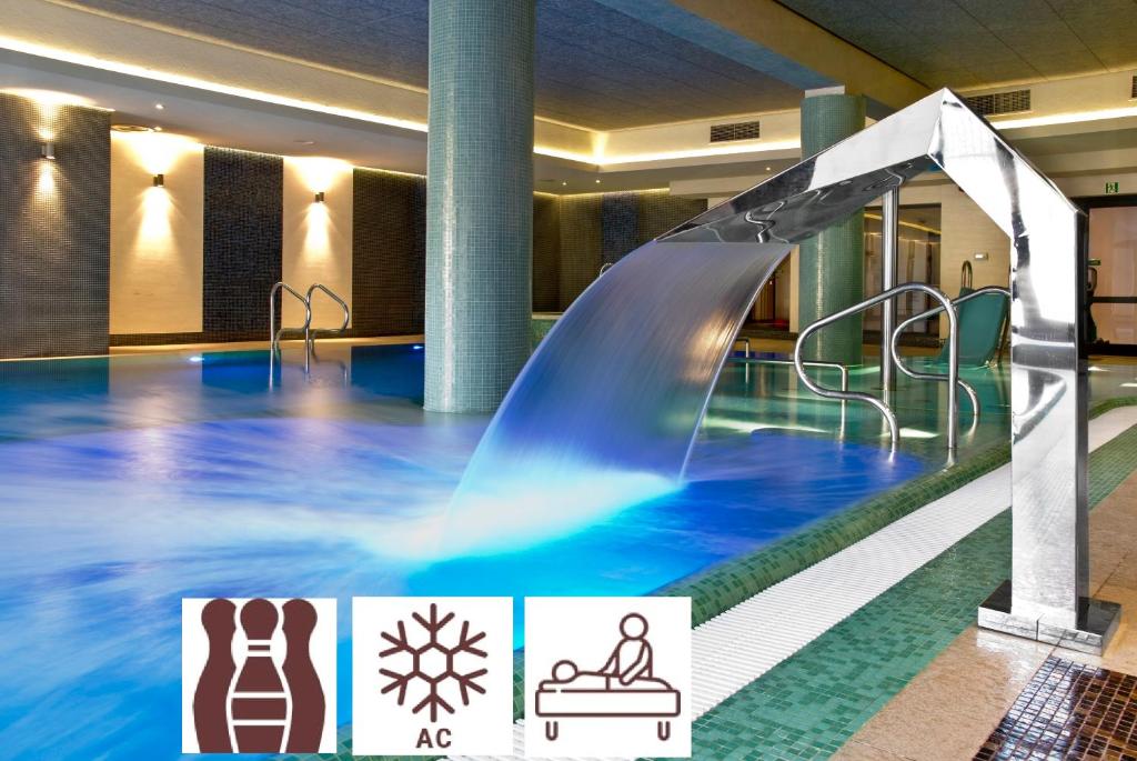 埃尔布隆格Hotel Młyn Aqua Spa Biblioteka的一座带水滑梯的室内游泳池