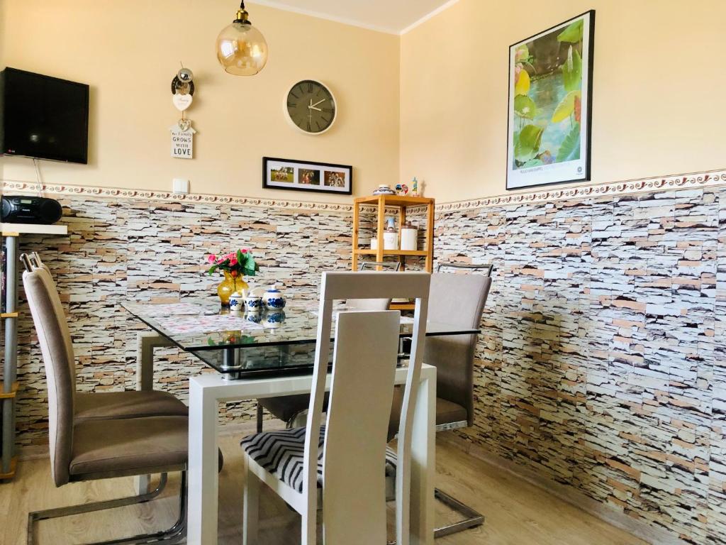弗瓦迪斯瓦沃沃Pokoje u Miecia na Jachcie的用餐室设有石墙、桌子和椅子