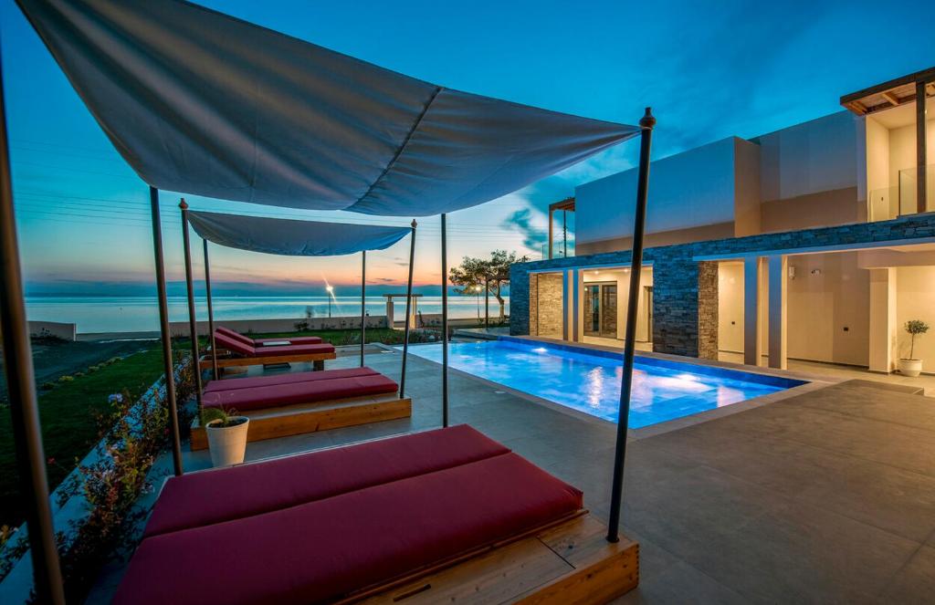 新马尔马拉斯Amyntas Seafront Hotel的一座带游泳池和房子的别墅