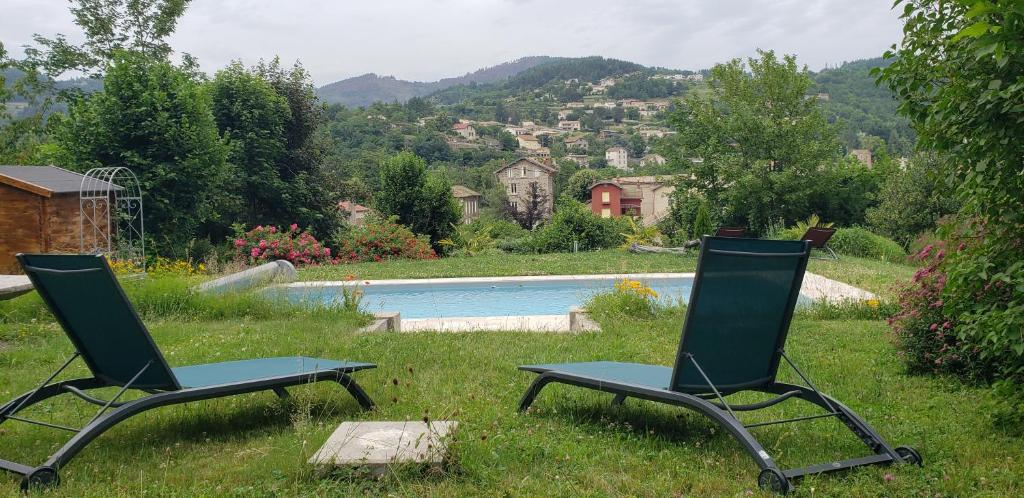 拉马斯特尔MaDolceVia Chambres d'hôtes au coeur de Lamastre的两把椅子坐在游泳池旁的草地上