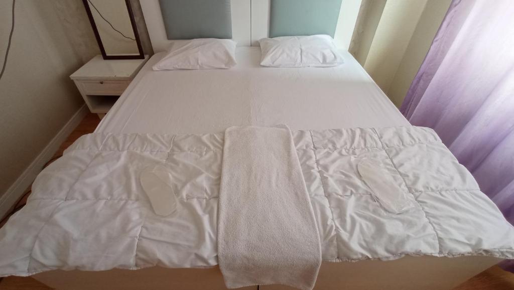 安塔利亚ESEN OTEL的一张带白色床单和毛巾的床