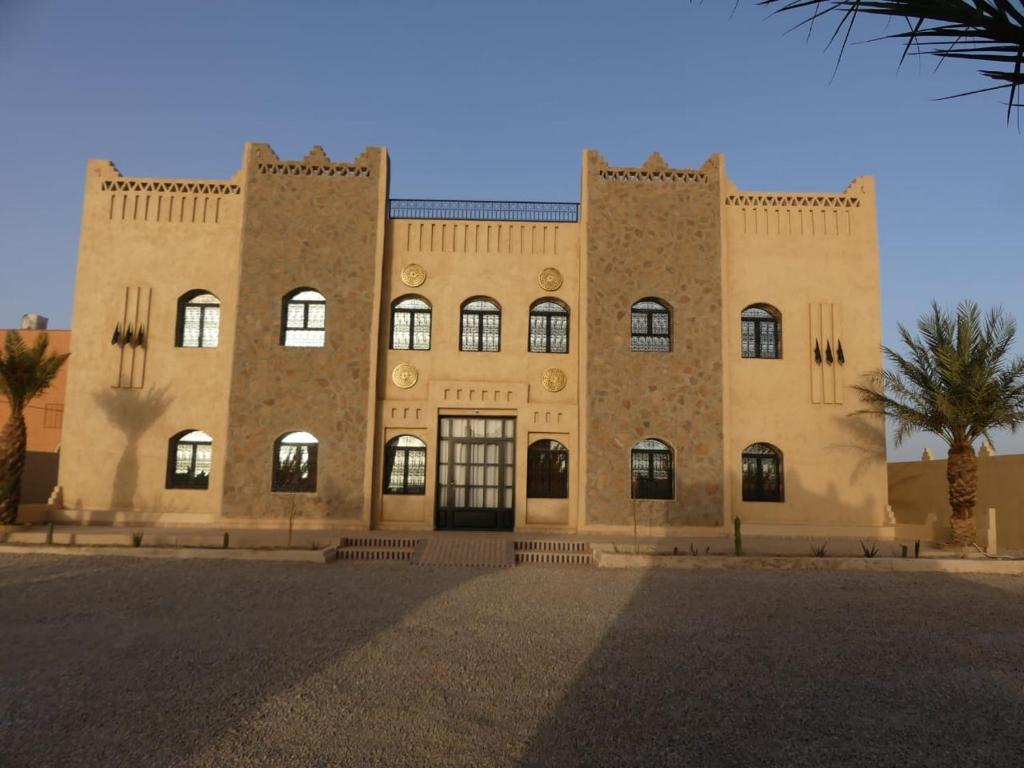 梅尔祖卡Riad La Luna的一座拥有许多窗户的大型砖砌建筑
