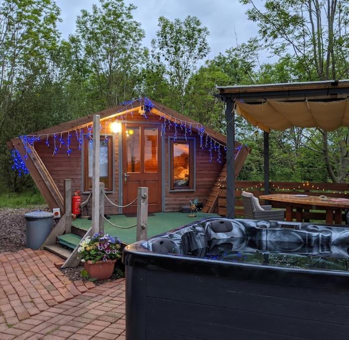 TuxfordWooden tiny house Glamping cabin with hot tub 1的小屋前方设有热水浴池