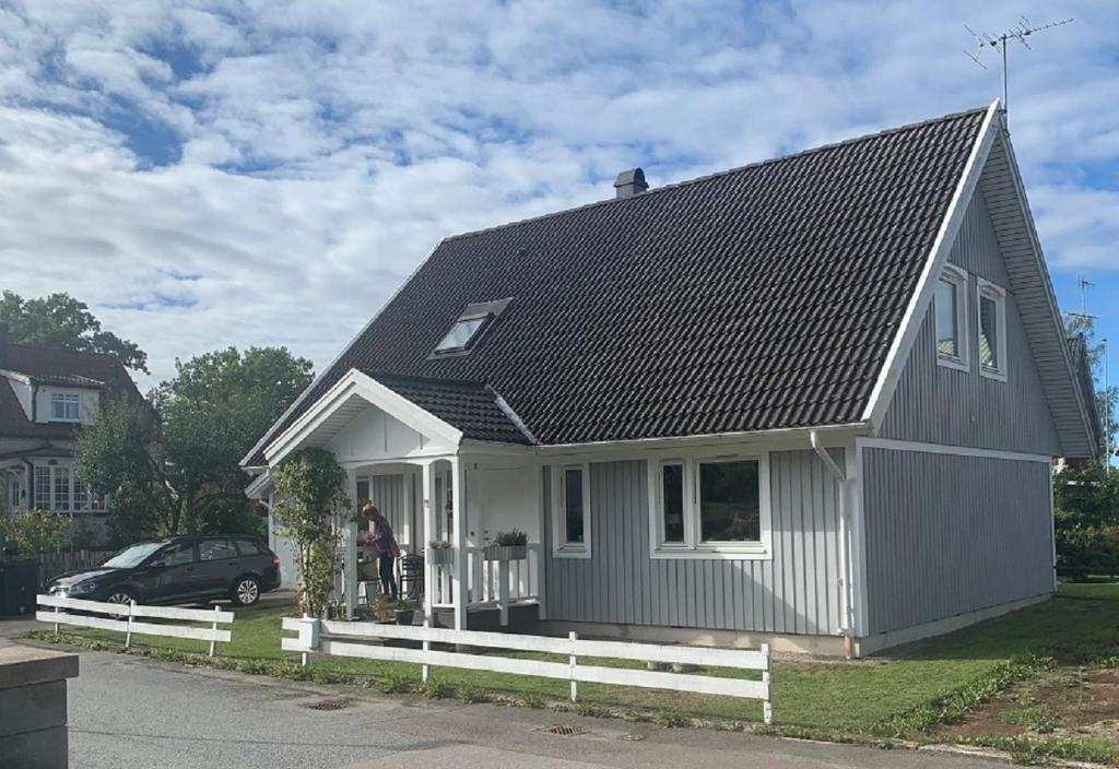 龙讷比Standard swedish family house的白色的小房子,有白色的栅栏