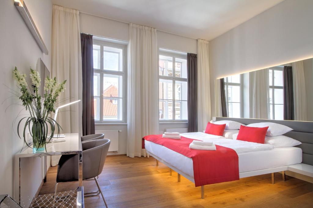 布拉格会督府酒店的卧室配有带红色枕头的大型白色床