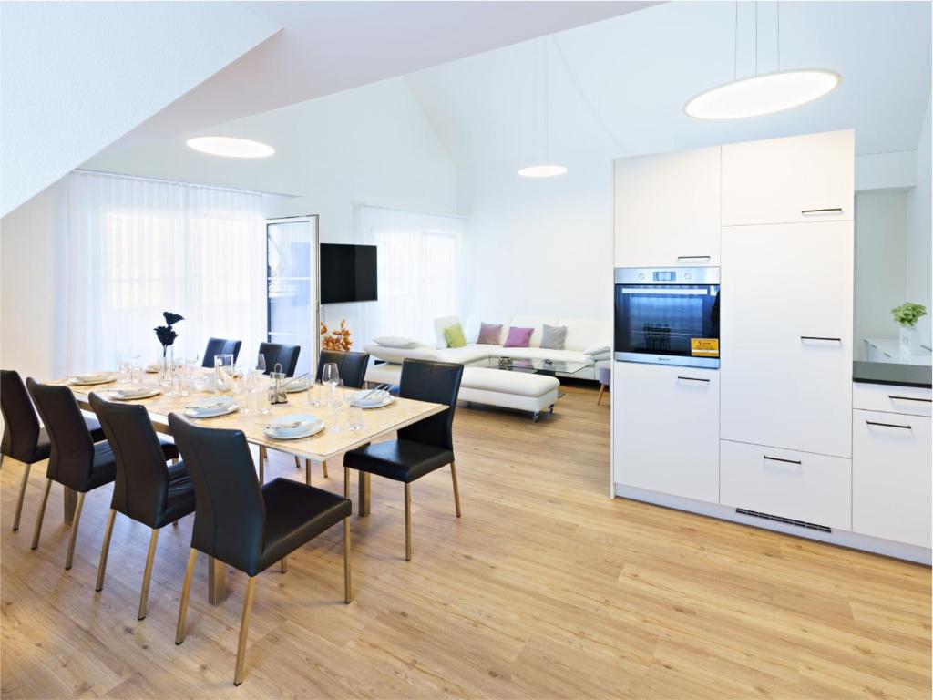 埃申茨Exklusive 4.5 Zimmer Wohnung für Familien und Business的厨房以及带桌椅的用餐室。