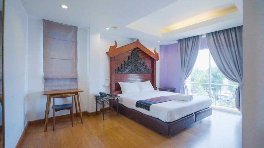 曼谷考巴豪斯酒店的一间卧室配有一张床、一张书桌和一个窗户。