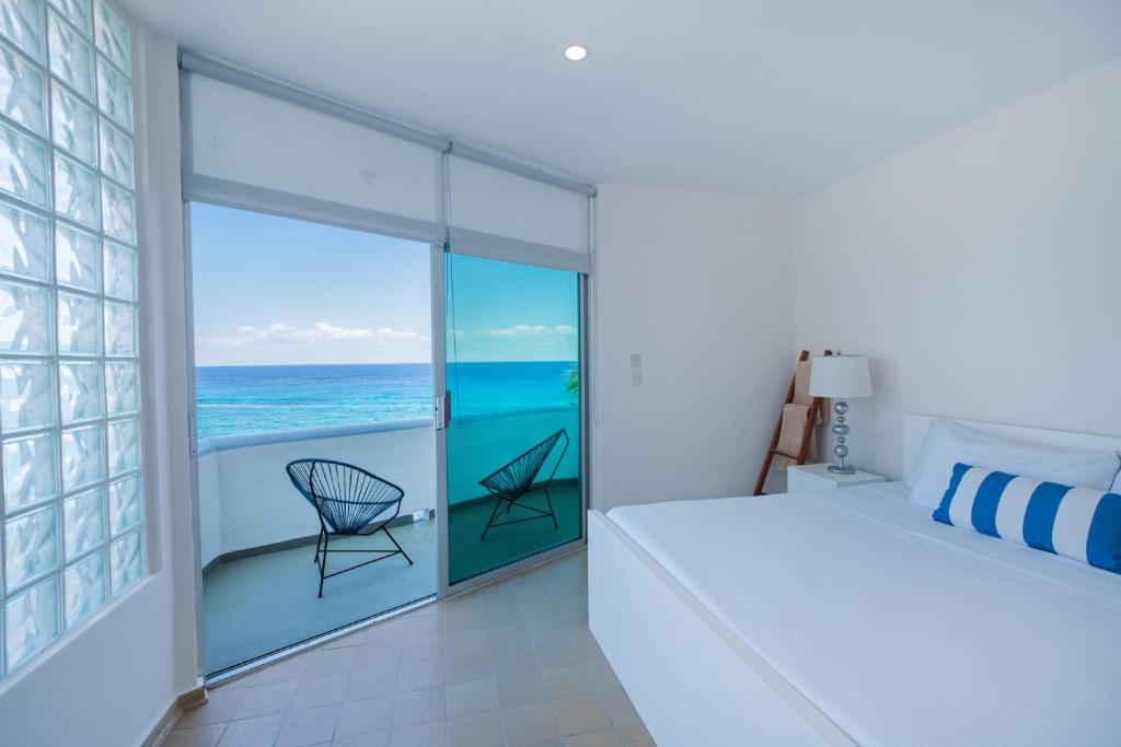 科苏梅尔Suites Turquesa的一间卧室配有一张床,享有海景