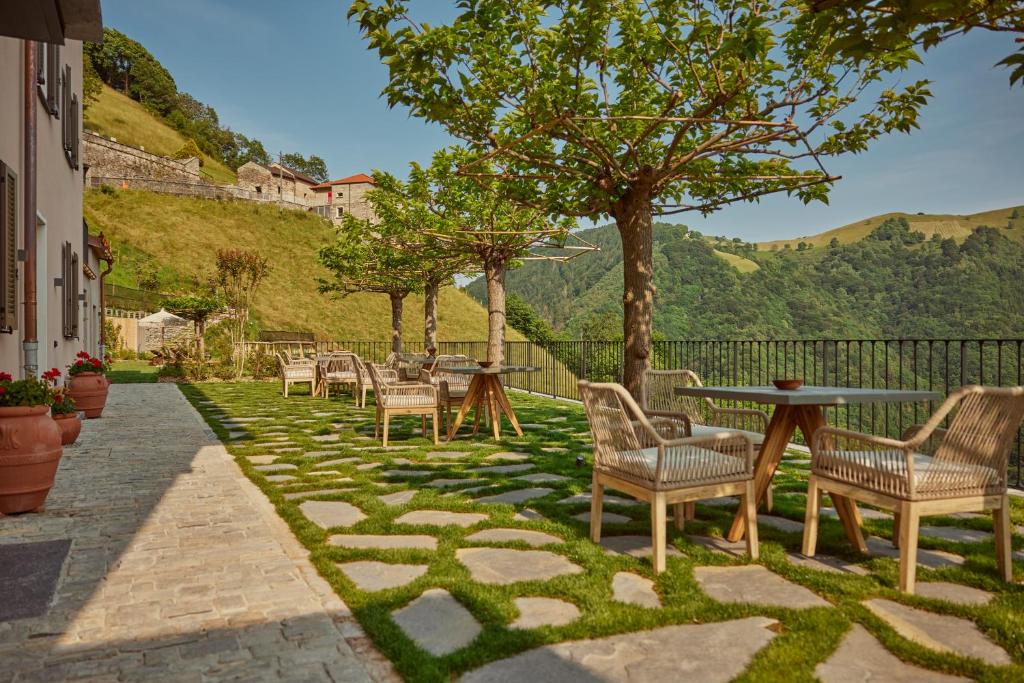 Scudellate"La Casa dei Gelsi" - Panorama Lodge MONTE GENEROSO的庭院配有桌椅和树木