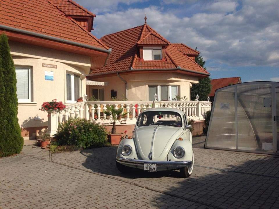 根尼斯迪亚斯Pihenés Háza-Relax Apartmanhaus的停在房子前面的白色小汽车